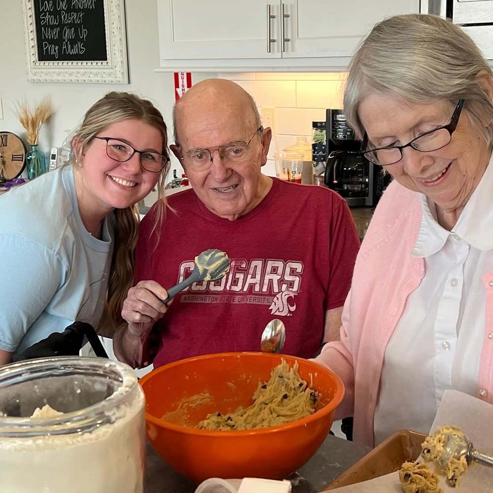 Residents and staff enjoying a baking activity at Cherry Creek AFH in Kennewick.